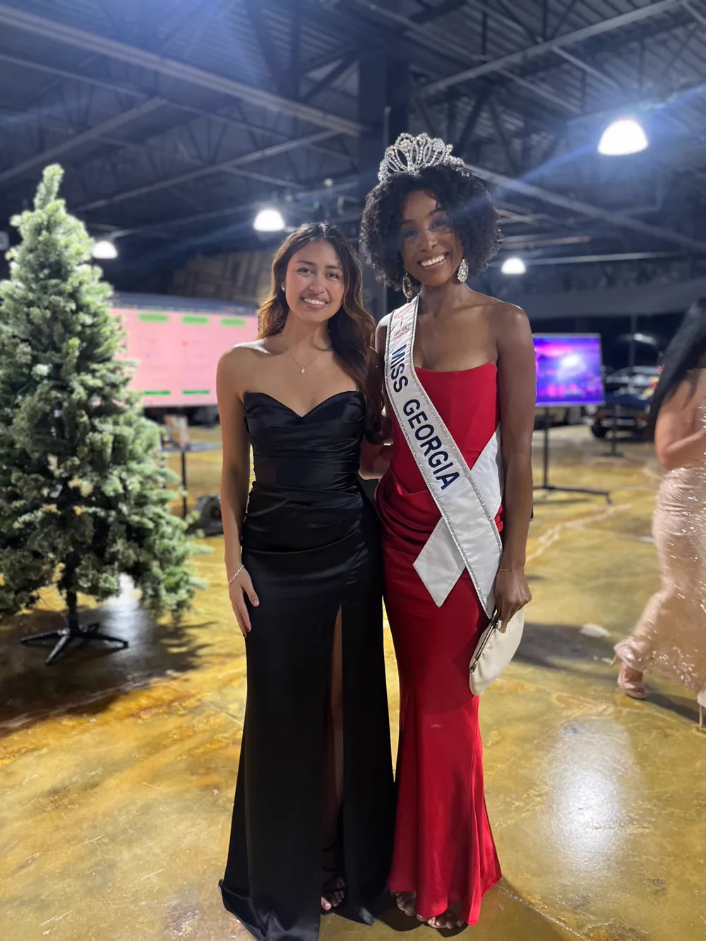 Two gala guests in formal eveningwear near a decorated tree